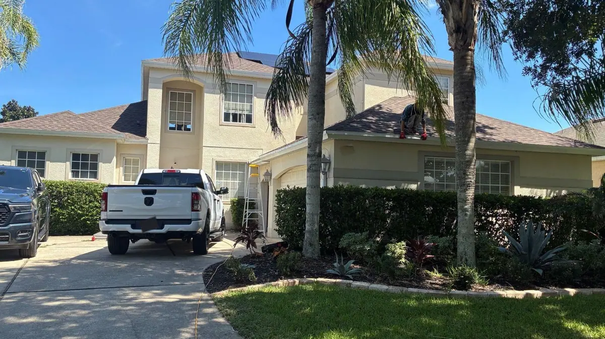 Premium Gutter Solutions crew working along the gutter line of a two-story home