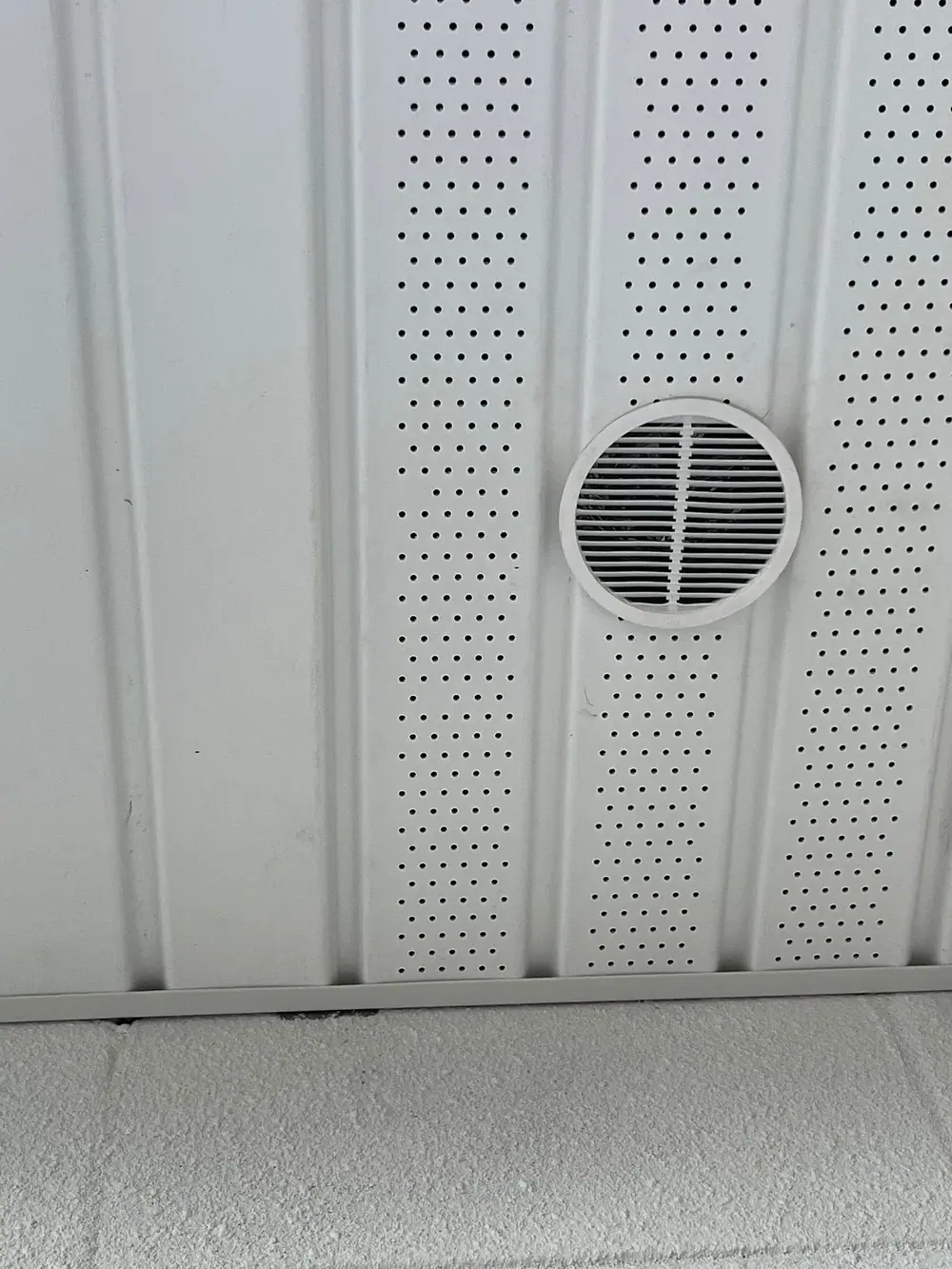 Vented white soffit panels with a round vent under the eave