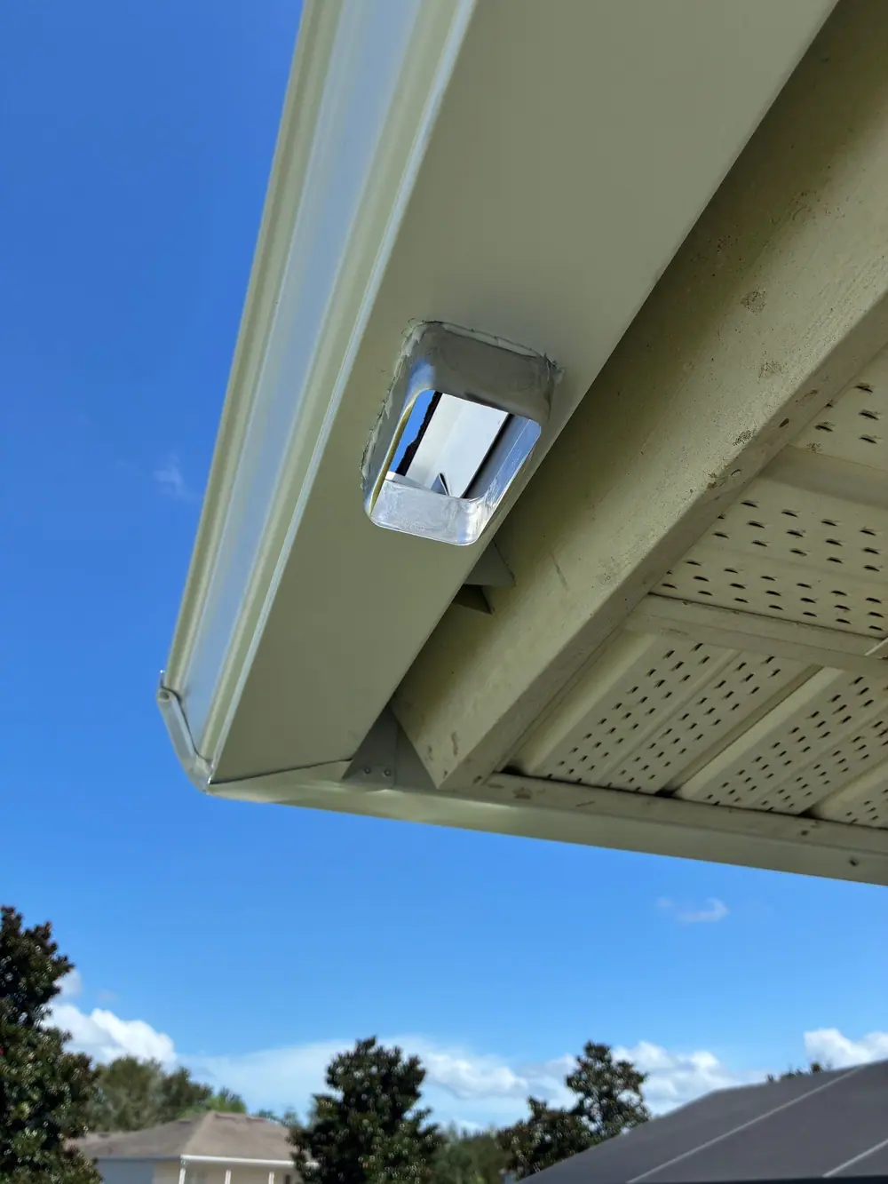 Close-up of a new drop outlet cut into a gutter, seen from below